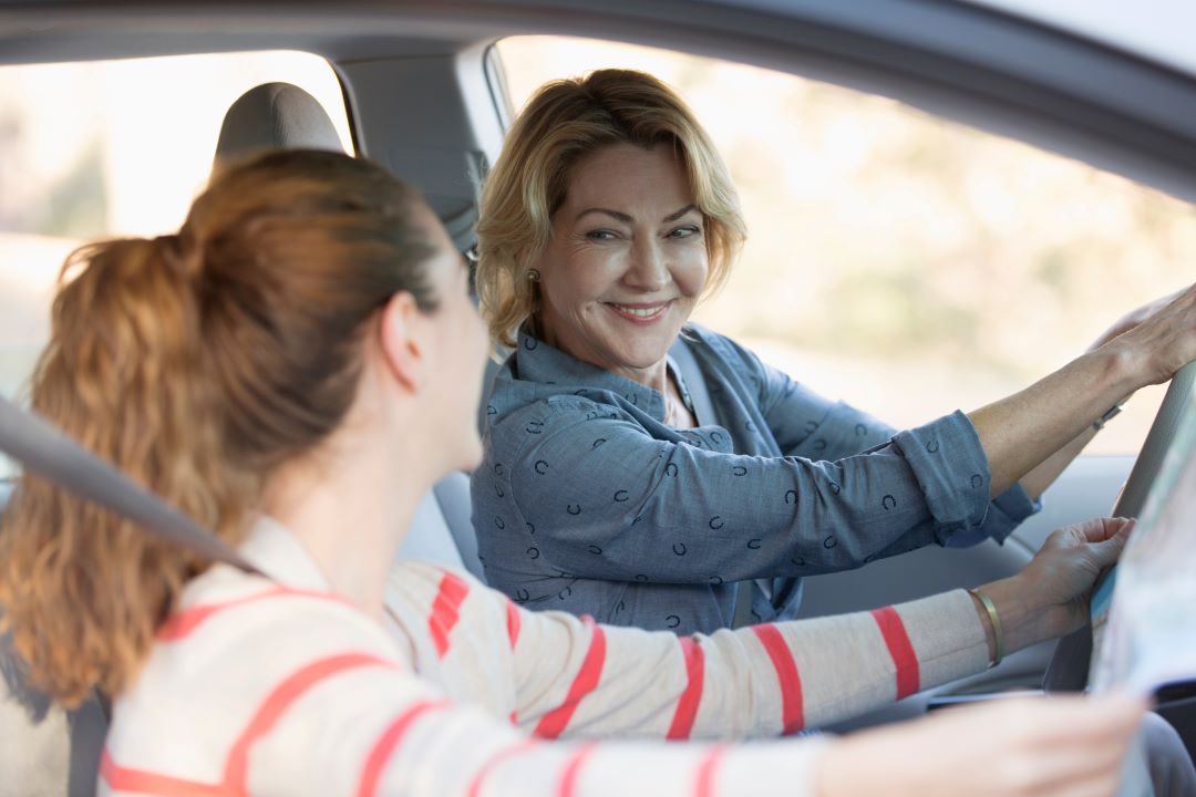 2 women in a car with a map